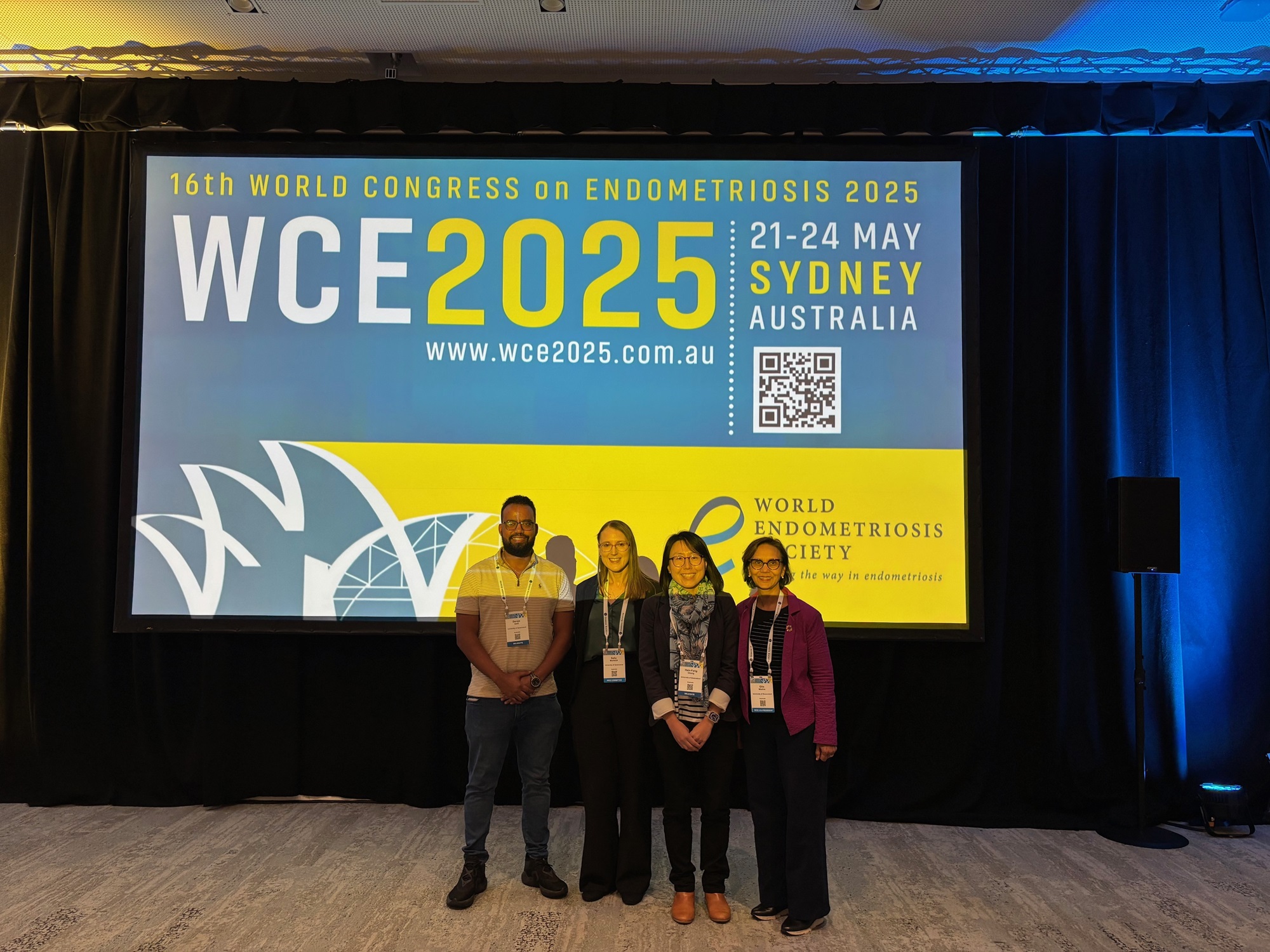 Dr Dereje Gete, Dr Sally Mortlock, Dr Hsin-Fang Chung and Prof. Gita Mishra standing in front on a screen at the WCE25.