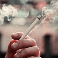 Hand holding lit cigarette
