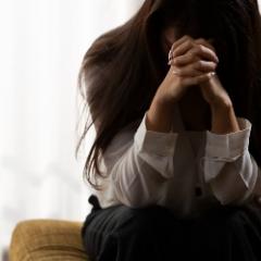 Woman sitting with forehead resting on her fists